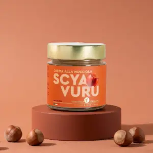 Pot de 200 g de crème de noisette Scyavuru 22 % sur un plateau en terre cuite avec des noisettes