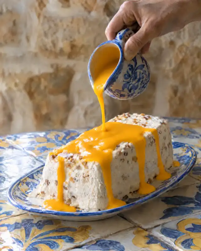 Versare il topping all'arancia sul parfait alle mandorle sformato