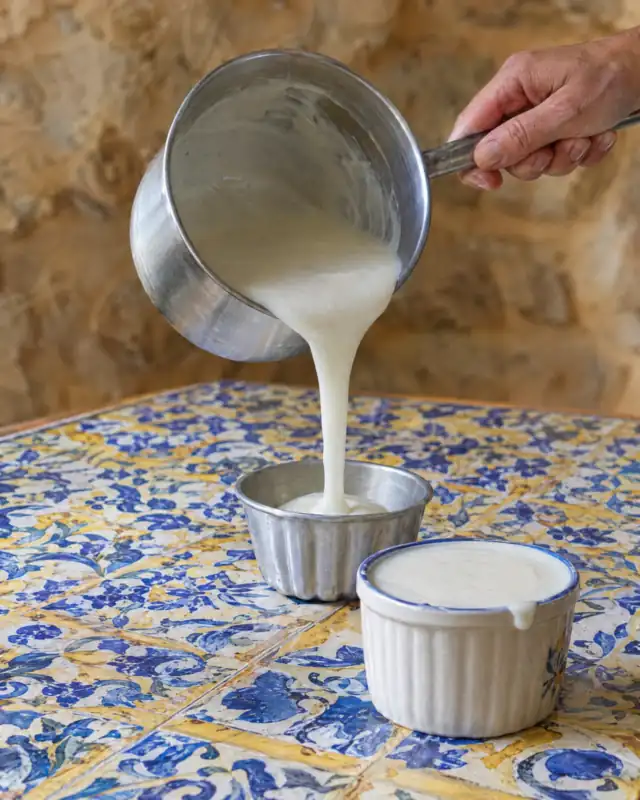Versare il composto del budino di mandorle in piccoli stampi