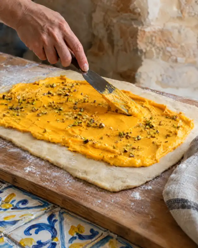 Spalmare la Crema all'Arancia Scyavuru sull'impasto per brioche steso