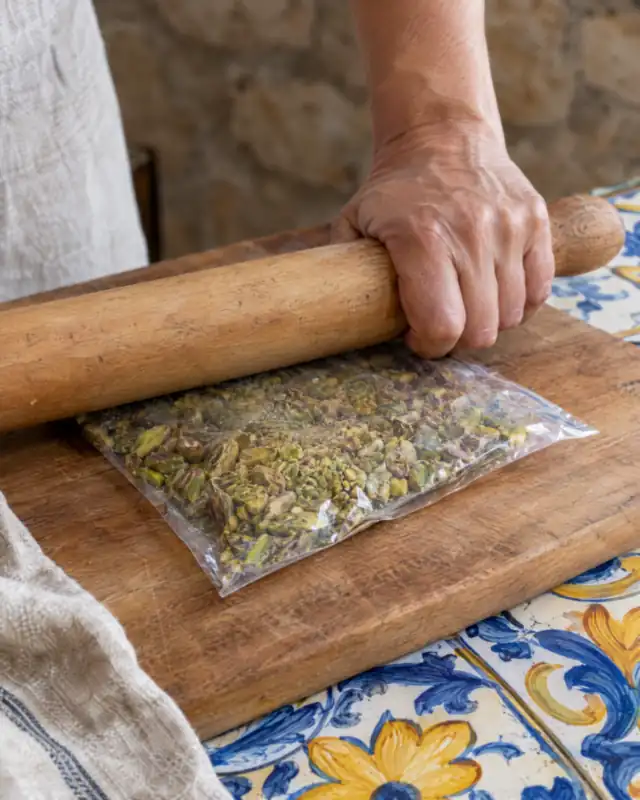 Tritare i pistacchi in un sacchetto con un mattarello