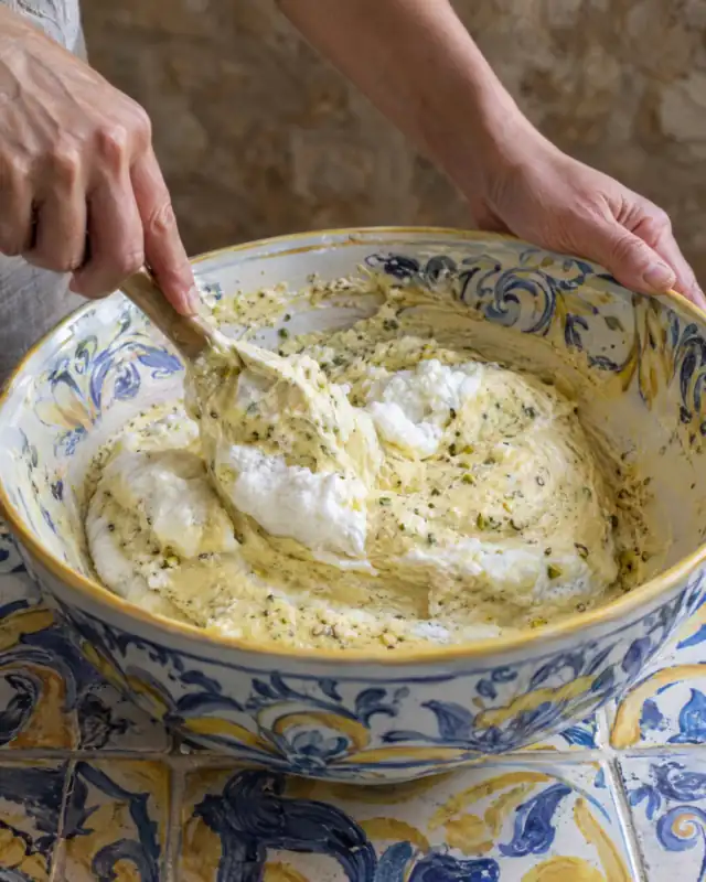 Incorporare l'impasto della torta al pistacchio in una ciotola blu