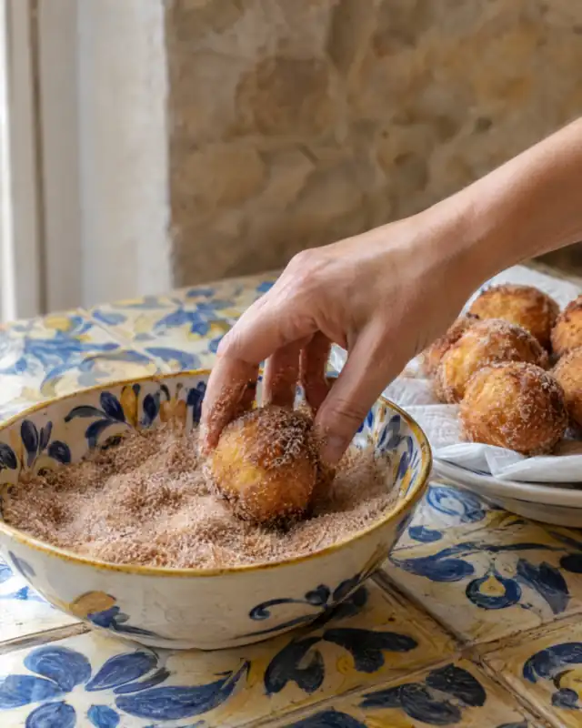 Passare un'arancina fritta nello zucchero alla cannella
